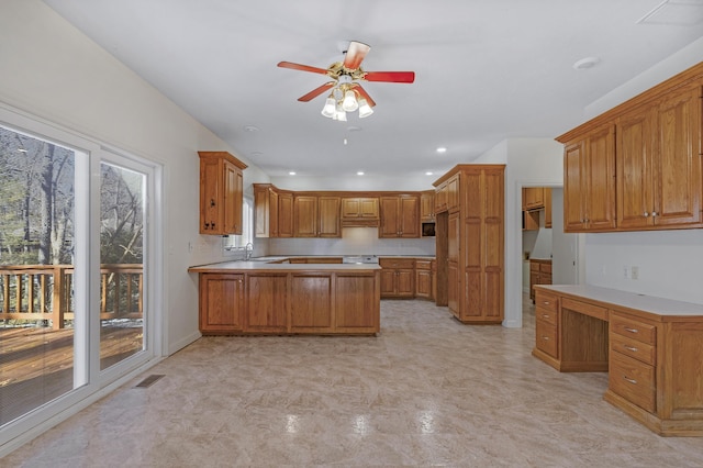 kitchen featuring sink, built in desk, and ceiling fan