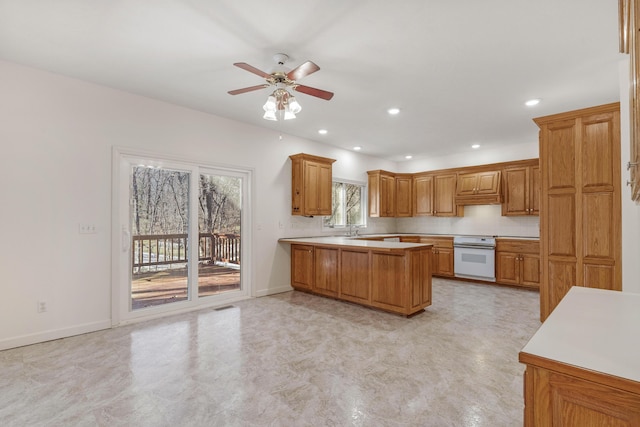 kitchen with oven, decorative backsplash, stove, ceiling fan, and kitchen peninsula