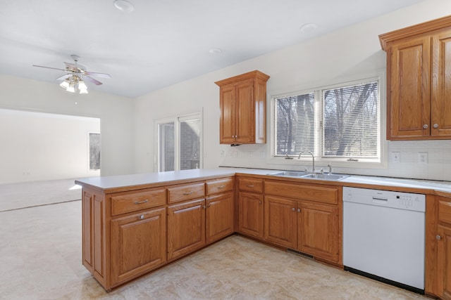 kitchen featuring kitchen peninsula, tasteful backsplash, sink, ceiling fan, and white dishwasher