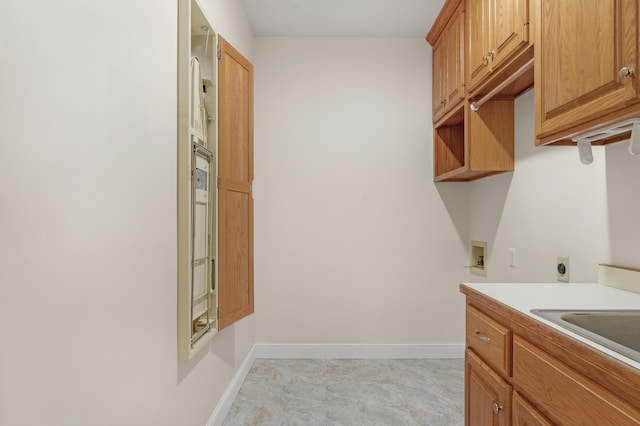 washroom with cabinets, electric dryer hookup, sink, and washer hookup