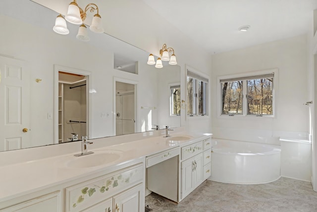 bathroom featuring a bathing tub, vanity, and a chandelier