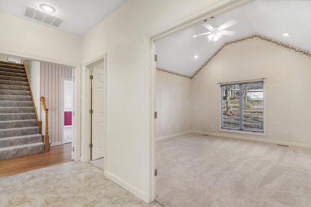 carpeted spare room featuring lofted ceiling and ceiling fan