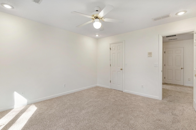 empty room with ceiling fan and light colored carpet