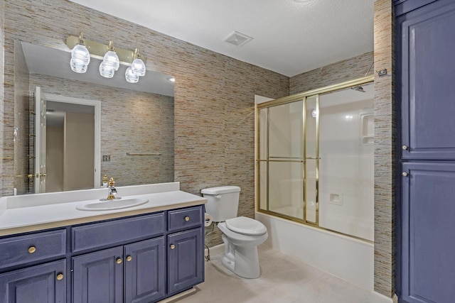 full bathroom featuring toilet, tile patterned floors, vanity, and bath / shower combo with glass door