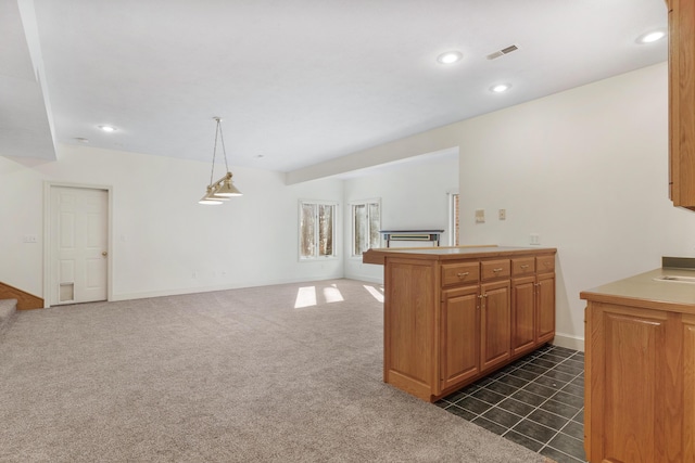 kitchen featuring decorative light fixtures, kitchen peninsula, and dark colored carpet