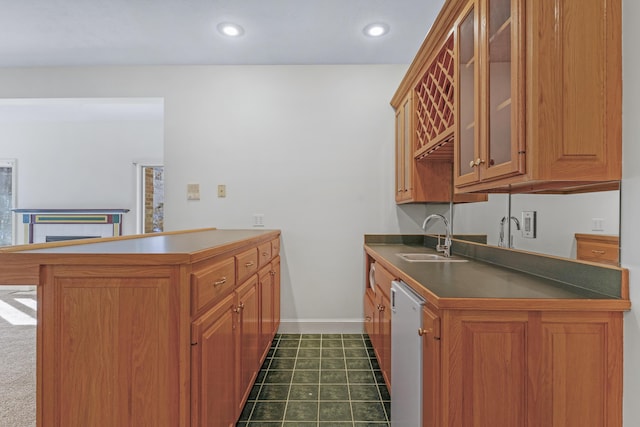 kitchen featuring dark tile patterned floors, sink, white dishwasher, and kitchen peninsula