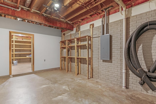 basement with brick wall and electric panel