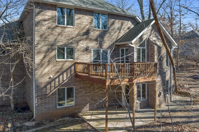 back of house featuring a wooden deck and a patio area