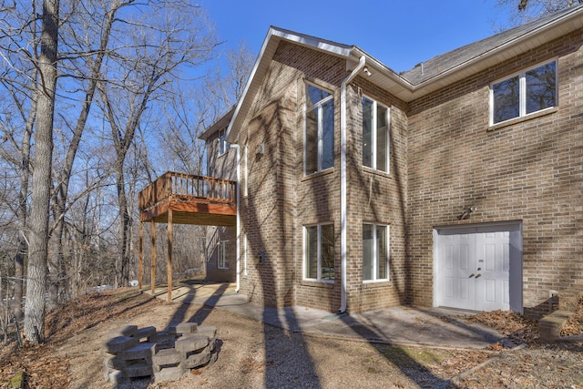 view of side of home with a wooden deck and a patio