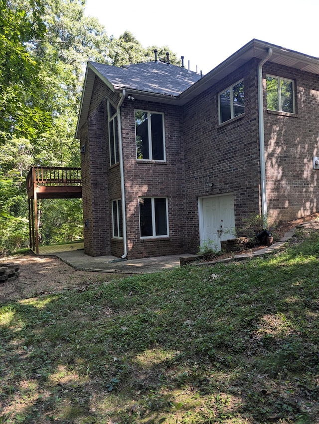 back of property with a patio, a wooden deck, and a yard