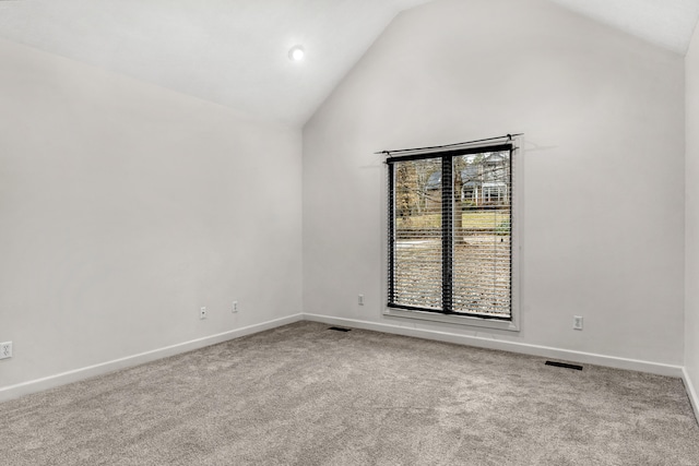 spare room with light carpet and high vaulted ceiling