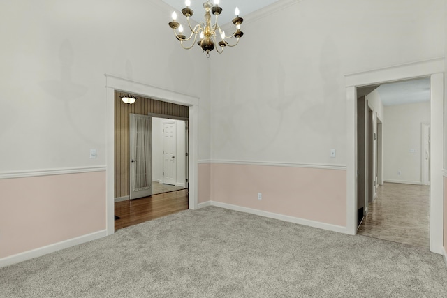 carpeted empty room with a chandelier and a high ceiling