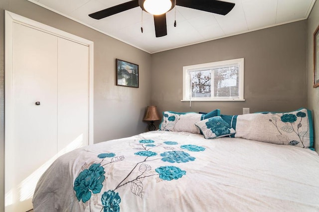 bedroom featuring ceiling fan, ornamental molding, and a closet