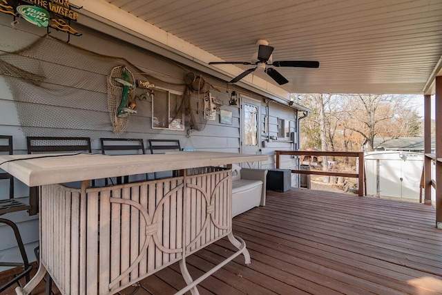 wooden deck featuring ceiling fan and exterior bar