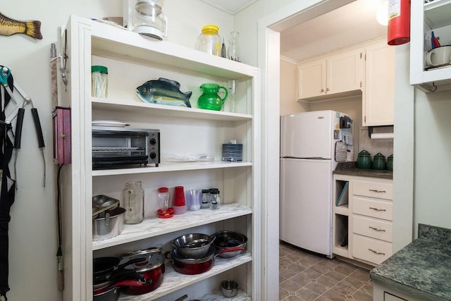 kitchen with white cabinetry and white fridge