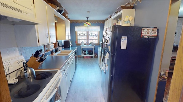 kitchen featuring white cabinetry, black refrigerator, white range with electric stovetop, pendant lighting, and sink