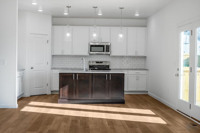 kitchen featuring decorative light fixtures, decorative backsplash, appliances with stainless steel finishes, and white cabinetry