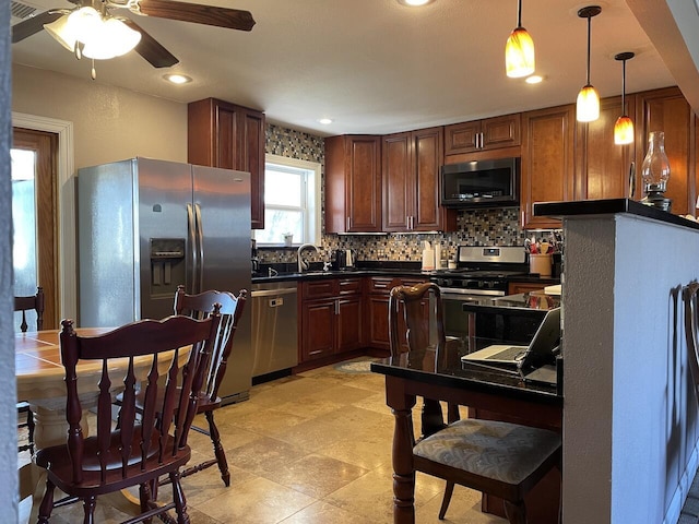 kitchen featuring ceiling fan, backsplash, sink, hanging light fixtures, and stainless steel appliances