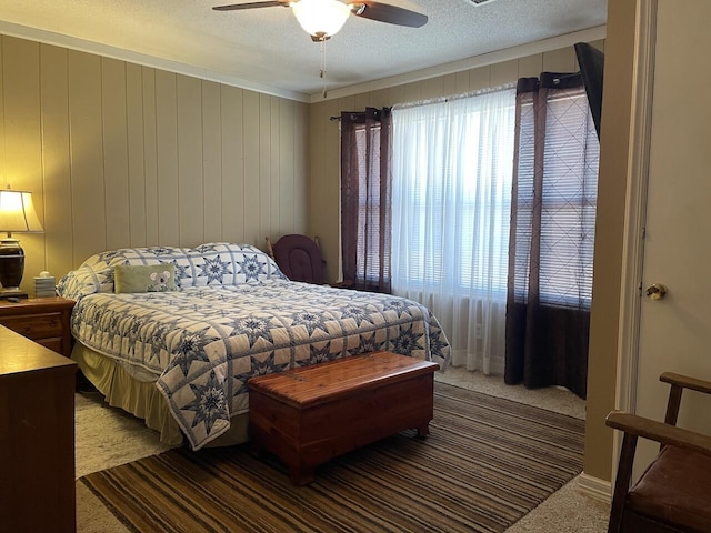 bedroom featuring ceiling fan, a textured ceiling, and carpet flooring