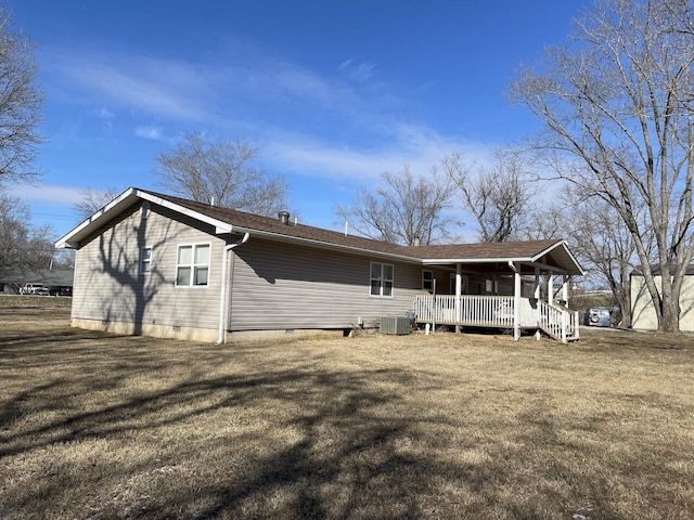 back of house featuring cooling unit, covered porch, and a yard