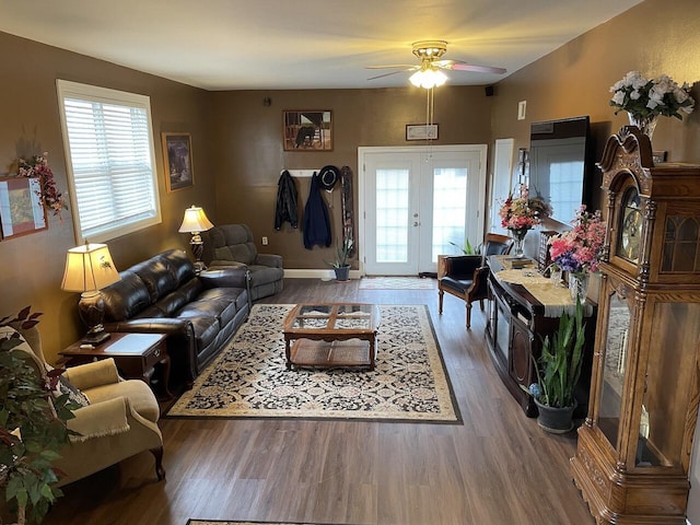 living room featuring ceiling fan, a healthy amount of sunlight, french doors, and dark wood-type flooring