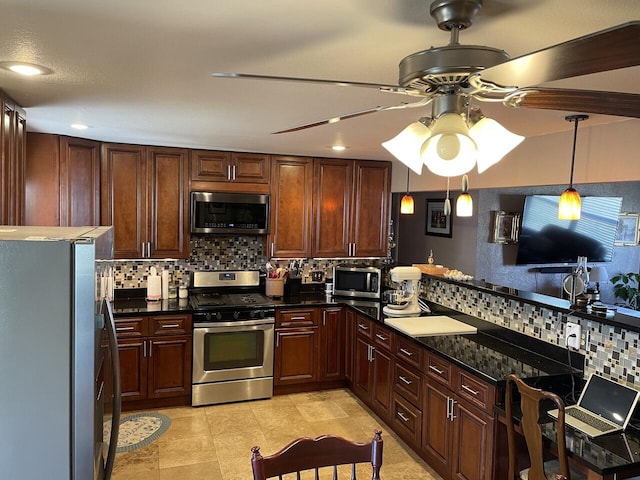 kitchen with pendant lighting, appliances with stainless steel finishes, dark stone countertops, backsplash, and ceiling fan