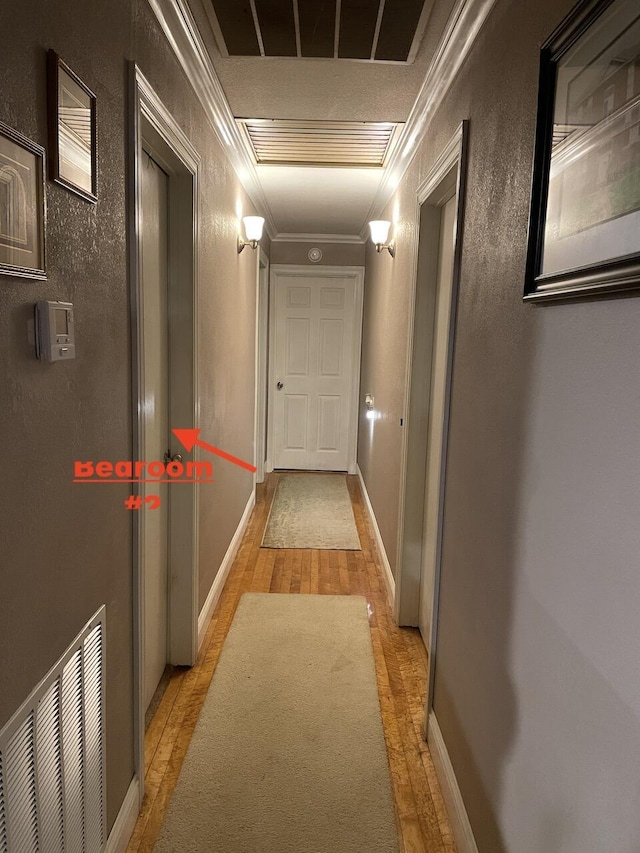 hallway featuring crown molding and light hardwood / wood-style floors