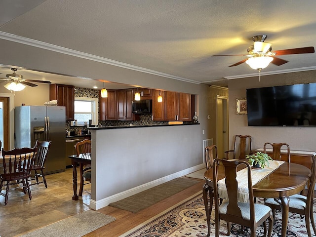 dining area featuring a textured ceiling, ceiling fan, and ornamental molding