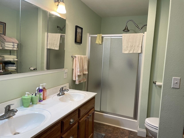 bathroom with vanity, toilet, and a shower with door