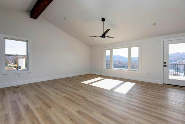 spare room with light wood-type flooring, a wealth of natural light, vaulted ceiling with beams, and baseboards