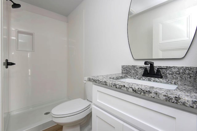 full bath featuring toilet, a shower stall, and vanity