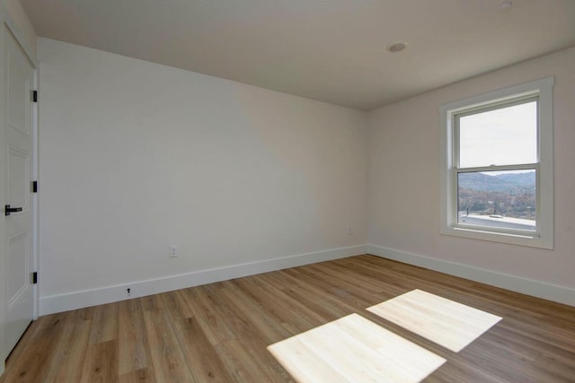 unfurnished room featuring light wood-type flooring and baseboards