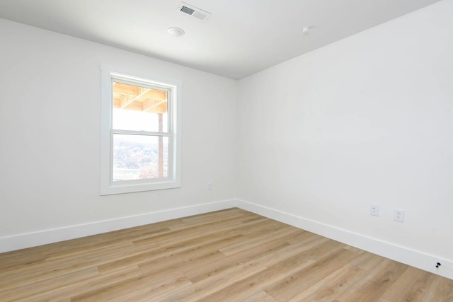 unfurnished room with baseboards, visible vents, and light wood finished floors