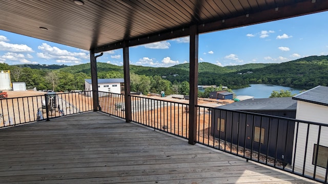 wooden deck featuring a water view and a view of trees