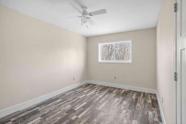 spare room featuring dark wood-type flooring and ceiling fan