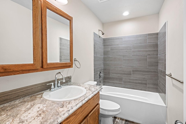 full bathroom featuring toilet, vanity, and tiled shower / bath