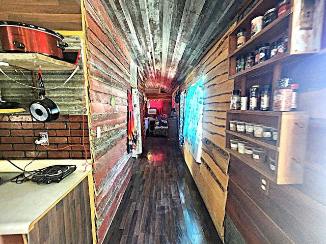 corridor with dark wood-type flooring, wood ceiling, and wooden walls