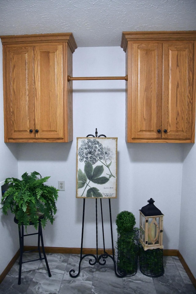 clothes washing area with a textured ceiling