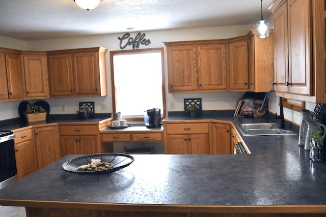 kitchen featuring sink, a textured ceiling, and hanging light fixtures