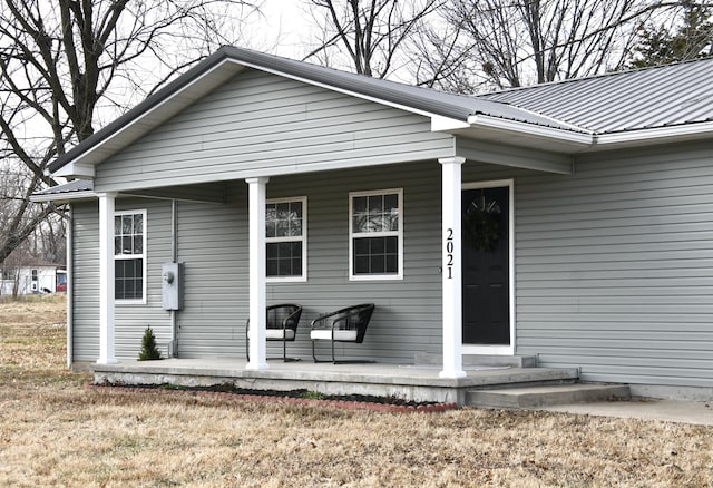 doorway to property featuring a yard and a porch