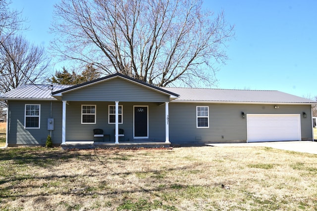 single story home with covered porch, an attached garage, metal roof, and a front yard