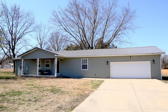 single story home with driveway, an attached garage, covered porch, a front lawn, and metal roof