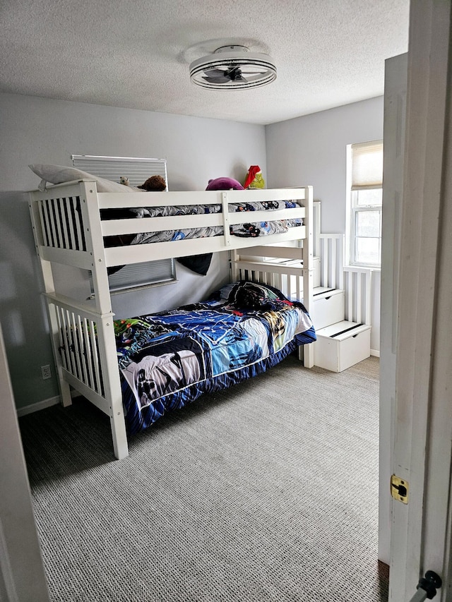 bedroom with carpet and a textured ceiling