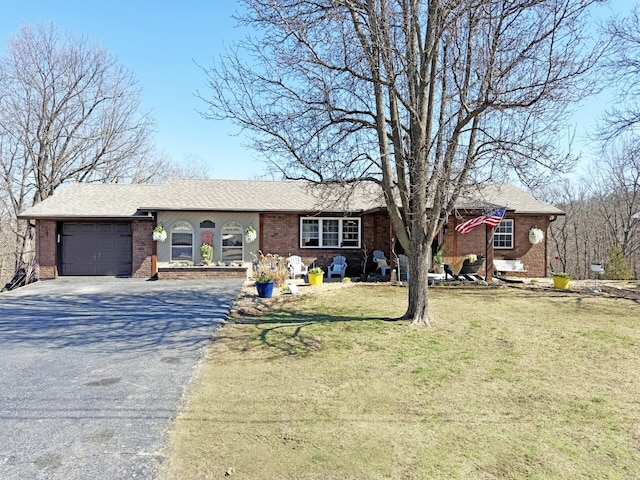 ranch-style house featuring a front yard, brick siding, a garage, and driveway