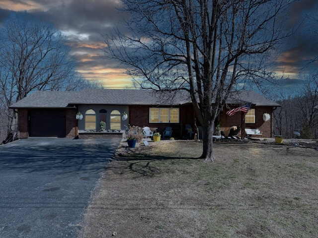 view of front of house featuring a garage, brick siding, driveway, and a shingled roof