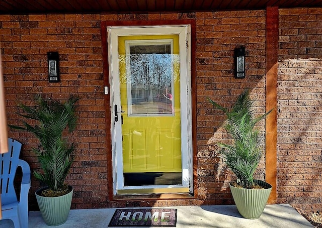 view of exterior entry with brick siding