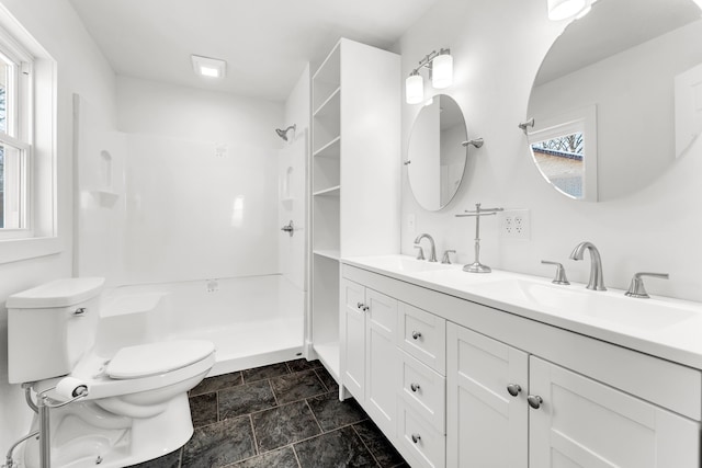 bathroom featuring toilet, a wealth of natural light, a shower, and vanity