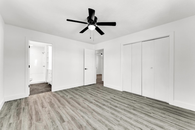 unfurnished bedroom with ceiling fan, ensuite bathroom, a closet, and light hardwood / wood-style flooring