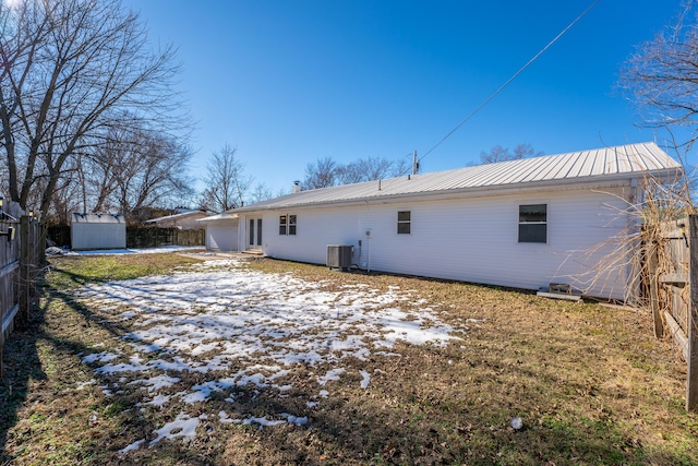 back of house with central air condition unit and a storage unit