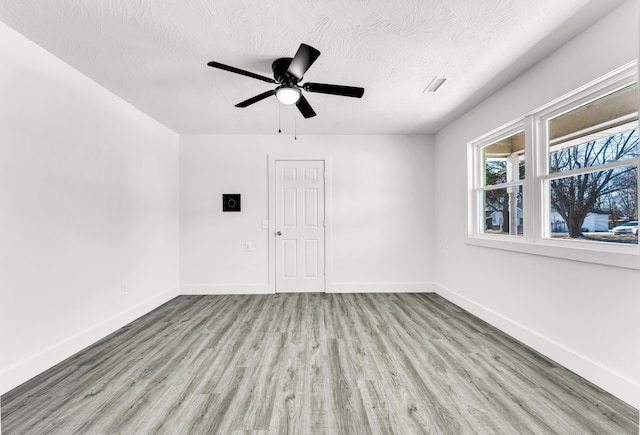 spare room featuring ceiling fan, a textured ceiling, and light hardwood / wood-style floors